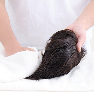 ウィッグを手に持ったままタオルで包み優しく水分を取ります。このとき擦らないように注意してください。