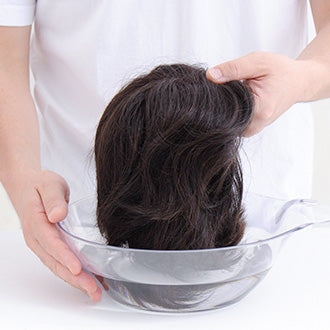 シャンプーを溶かした洗面器にウィッグ全体をゆっくり浸します。