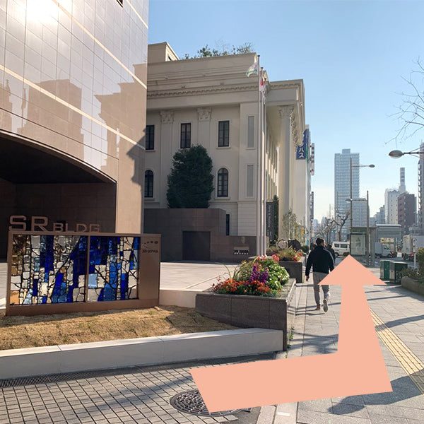 階段を上がった方向のまま、大きな茶色のビルを左手に直進します。